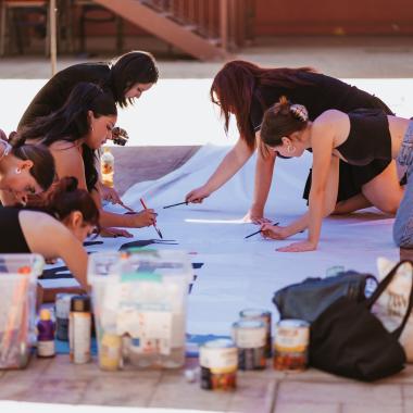 Participantes pintan el lienzo